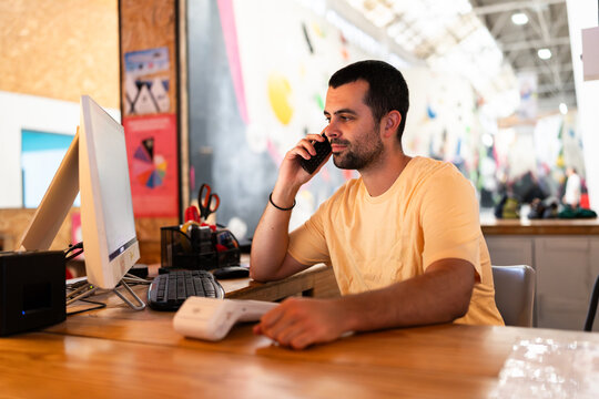 Man talking on phone working at climbing gym reception