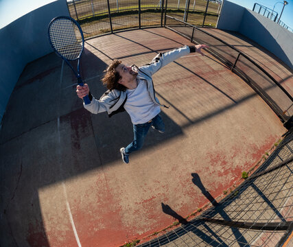Young Player Executes a Backhand Serve on a Tennis Court