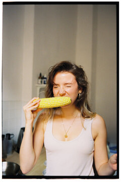 portrait of young woman eating boiled corn