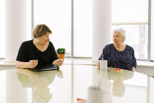 Two Women Enjoying a Conversation in a Bright, Modern Room