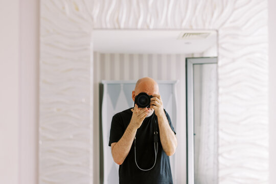 Elderly Man Taking a Selfie in a Modern Bathroom Mirror