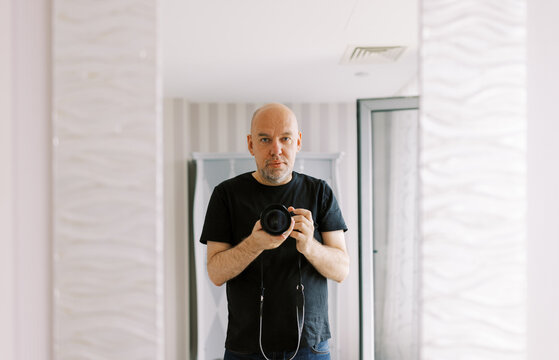 Man Taking a Selfie in a Bright Hotel Room Mirror