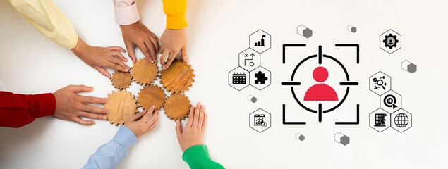 Hands of diverse individuals working together to assemble gears symbolize collaboration and...