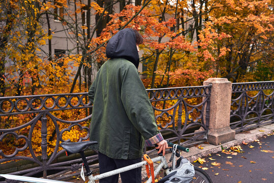 Woman walking with a bicycle through autumn scene