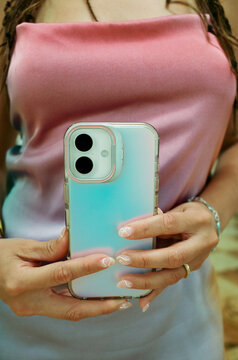 Holding a Smartphone With a Colorful Case in a Casual Setting