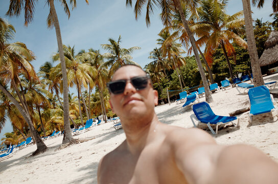 Relaxing on the Beach Surrounded by Palm Trees and Lounge Chairs