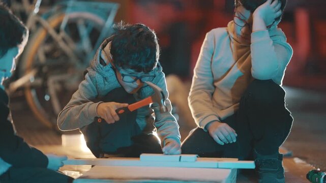 Young boy learning woodworking with a hammer