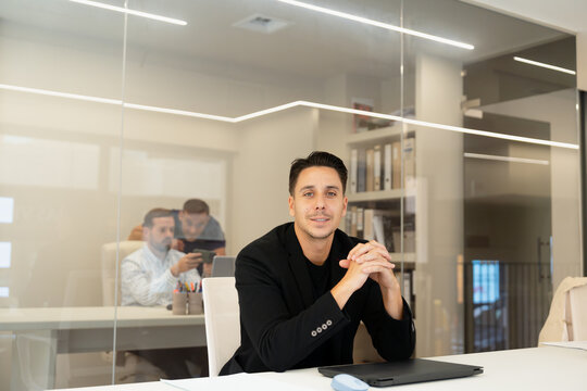 Man sitting at desk in office looking confident