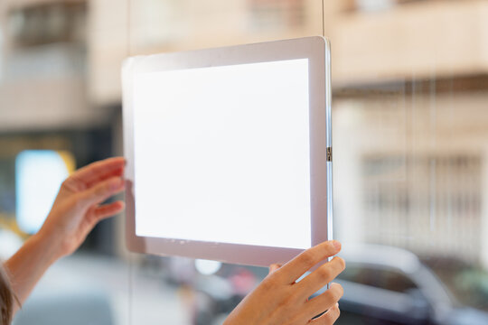 Hands adjusting illuminated display in office window
