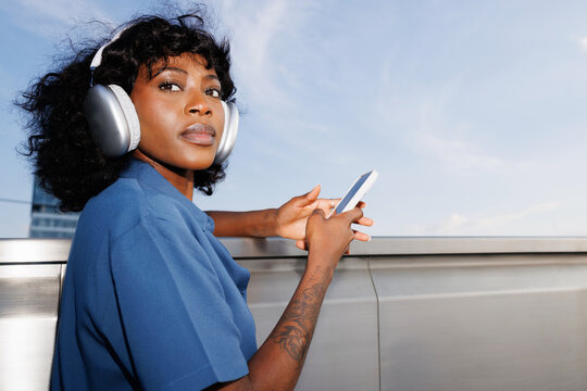 Portrait Woman Holding Phone with Headphones  Sky Background 