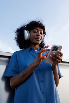 Woman Using Smartphone While Wearing Headphones