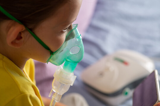 Child with a nibulaise mask inhales.