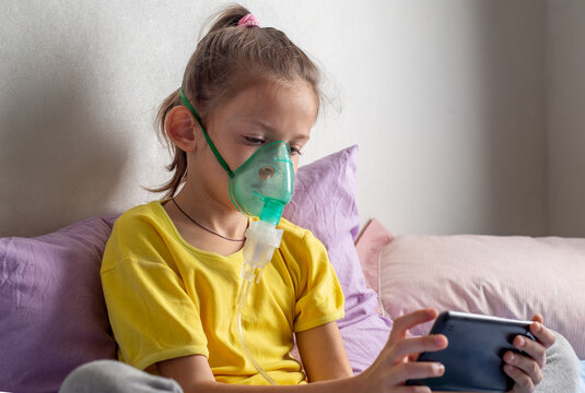 Child with a nibulaise mask inhales.