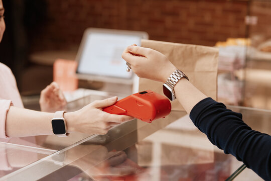 Customer using smart watch for contactless payment in cafe