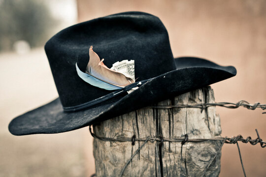 Galisteo, New Mexico, USA. cowboy hat on a fence post with a $2 bill in the headband