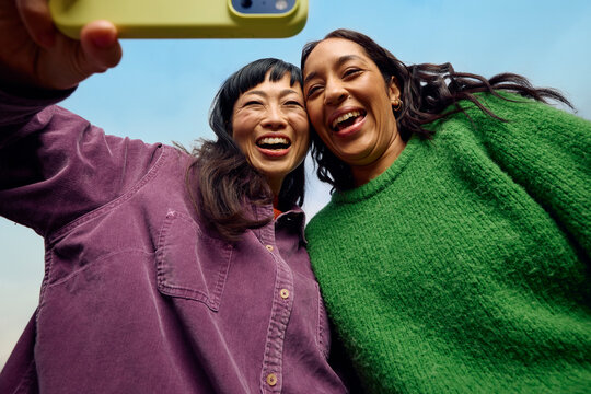Women enjoy capturing selfies in outdoor setting