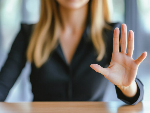 Junge Frau h&auml;lt Handfl&auml;che nach vorne in B&uuml;ro, um zu stoppen