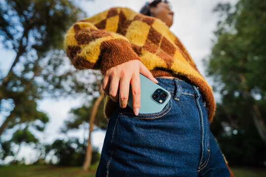 Woman takes out mobile phone from her pocket