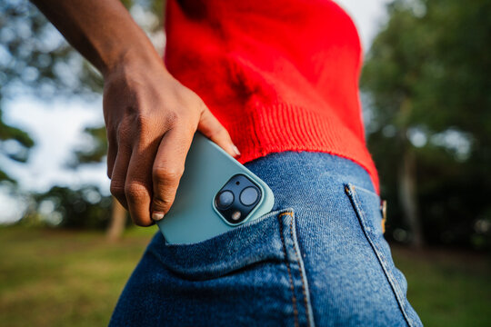 Woman takes out mobile phone from her back pocket