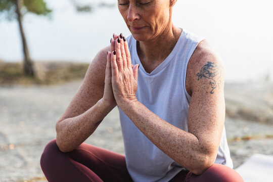 Serene Woman Meditating in Easy Pose by a Calm Lake