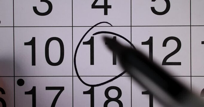 Footage of a calendar showing the date 11th reminder concept for the 11th day of the month with a black pen circling the date as a reminder of the day