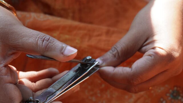Using a nail clipper to cut fingernails