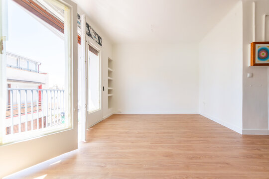 Luminous empty living room with wooden floor