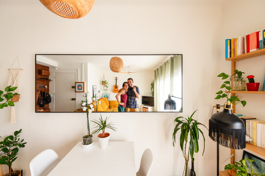 Cheerful Couple Selfie in Living Room Mirror