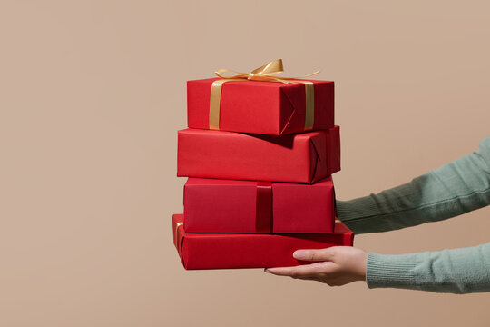 A person's hand is holding a tower of wrapped present