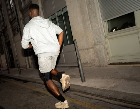 Man Jogging in City Streets at Night Wearing Comfortable Athletic Gear