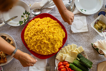 The authentic ritual of cutting hot mamaliga polenta with a wire, a staple of Moldovan and Eastern...