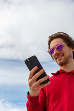 Person Enjoying a Sunny Day While Looking at Their Smartphone