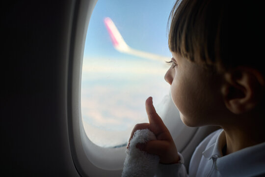Curious Child Looking Out Airplane Window
