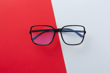 Stylish eyeglasses on color background, top view