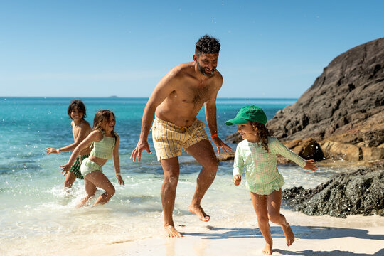 Family playing on tropical beach in Whitehaven beach