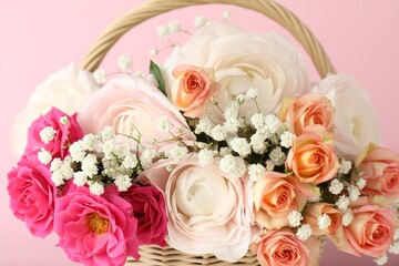 Obraz premium Beautiful flowers in basket on pink background, closeup