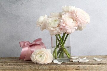 Beautiful flowers and gift on wooden table