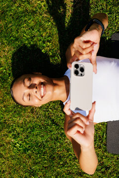 Portrait Woman Lying on Grass Holding Smartphone