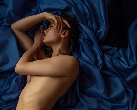 A girl laying on a bed looking to the camera