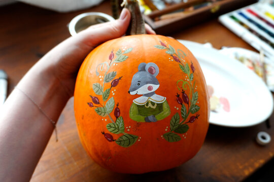 Illustration of a little mouse painted on a pumpkin