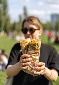Young woman holding wraps in a public park