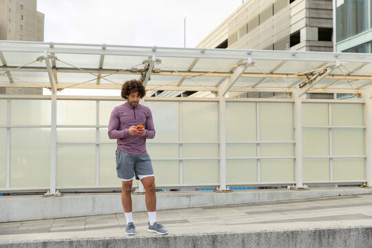 Casual standing Portrait black man mobile  phone outdoors 