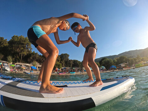 Kids Enjoy Paddleboarding and Playing on Water Under the Sun