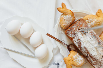 Bakery setup with baked goods and eggs on a kitchen table during a festive gathering in spring