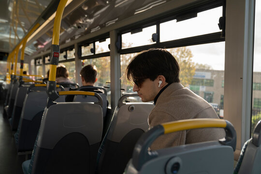 Young Man Enjoys Music on a Modern Bus Ride
