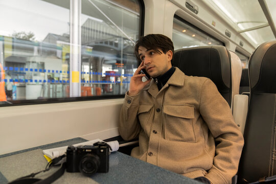 Student Relaxes on Train While Reading and Texting