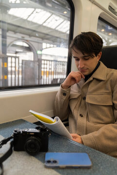 Young Man Reads and Relaxes on Train During Morning Commute