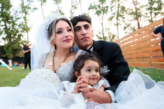 Newlyweds Posing with a Child at the Wedding