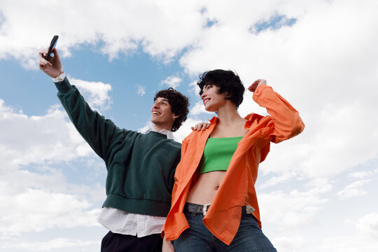 Friends Take a Selfie Outdoors With a Bright Sky in the Background