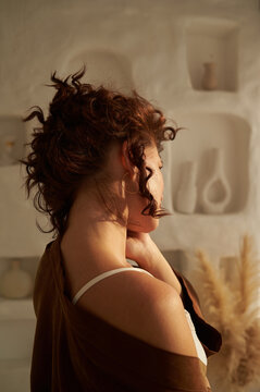 Brunette woman stands with her back turned